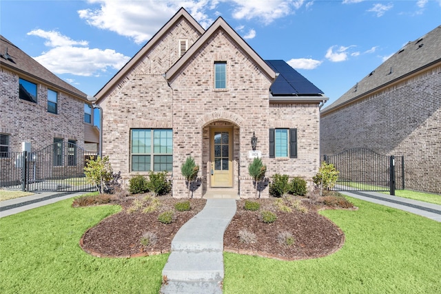 view of front of home featuring a front lawn and solar panels