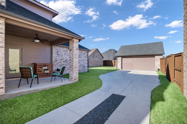 view of yard featuring ceiling fan, a patio area, a garage, and an outdoor structure