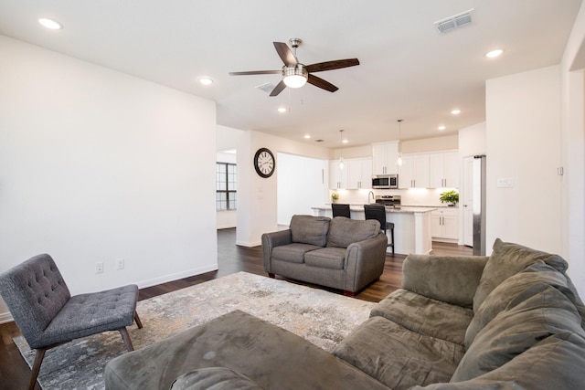 living room with ceiling fan and dark hardwood / wood-style flooring