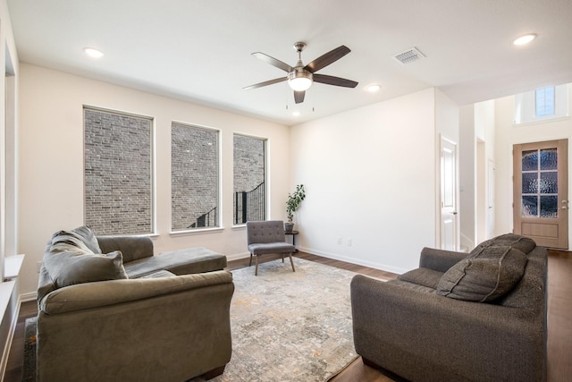 living room with dark hardwood / wood-style flooring and ceiling fan