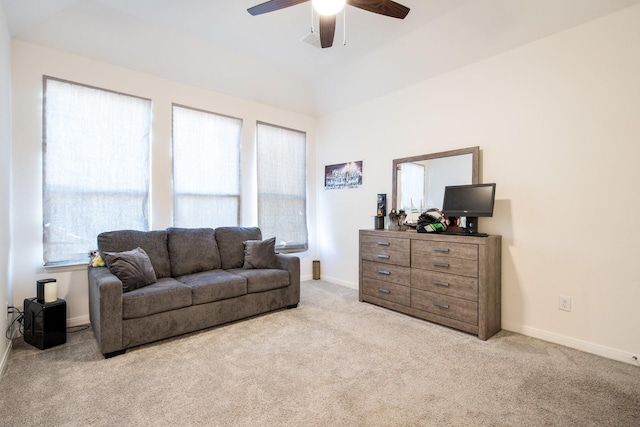 carpeted living room with ceiling fan and vaulted ceiling