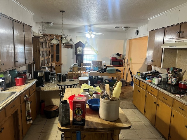 kitchen with ceiling fan, light tile patterned floors, a textured ceiling, and black cooktop