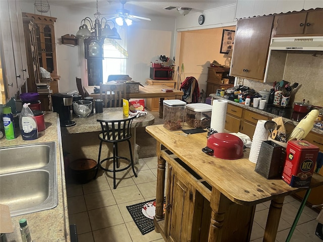 kitchen with sink, light tile patterned floors, and an inviting chandelier