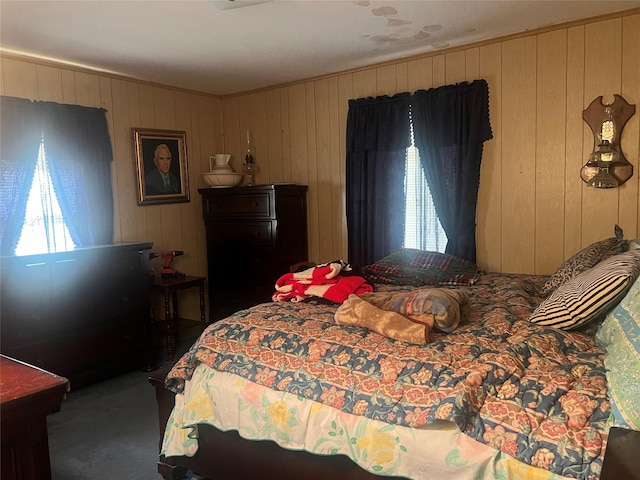 bedroom featuring crown molding and dark carpet