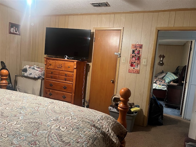 carpeted bedroom with wooden walls and a textured ceiling