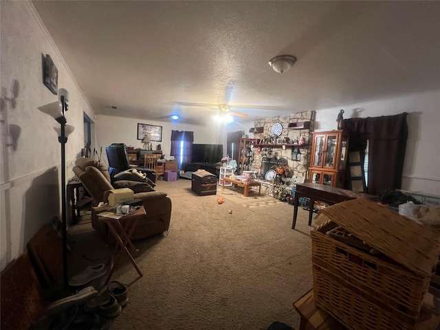 carpeted living room featuring a fireplace, ceiling fan, ornamental molding, and a textured ceiling