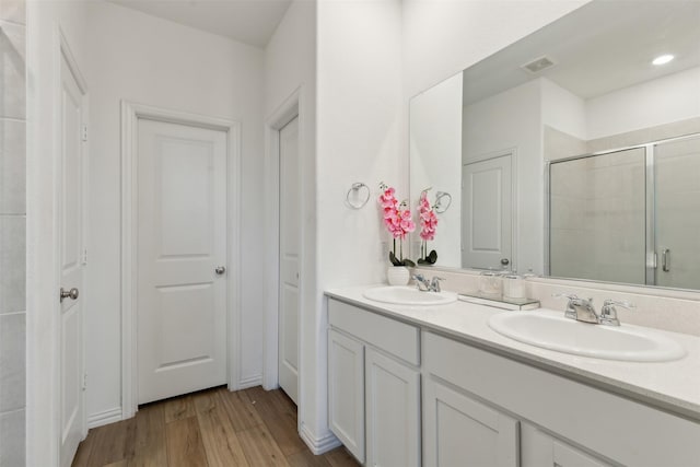 bathroom featuring vanity, an enclosed shower, and hardwood / wood-style flooring