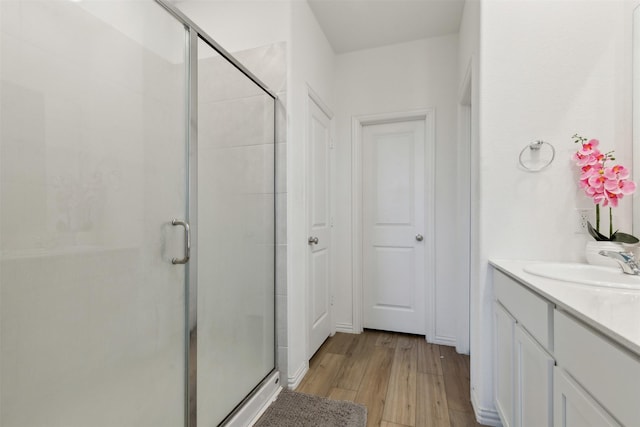 bathroom featuring vanity, hardwood / wood-style flooring, and a shower with shower door