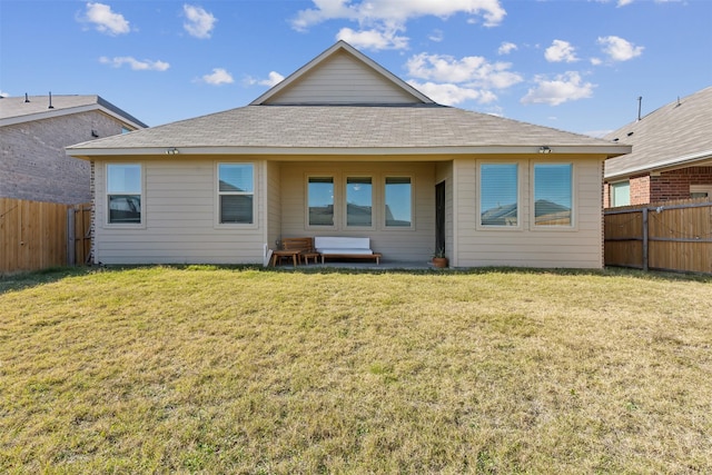 rear view of property featuring a lawn