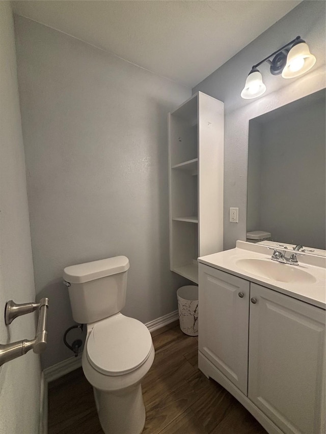 bathroom with vanity, toilet, and wood-type flooring