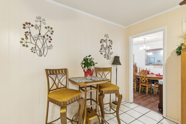 dining area with a chandelier, light wood-type flooring, crown molding, and wood walls