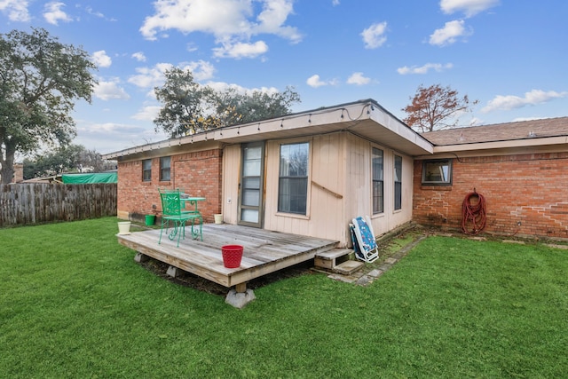 back of property featuring a yard and a wooden deck