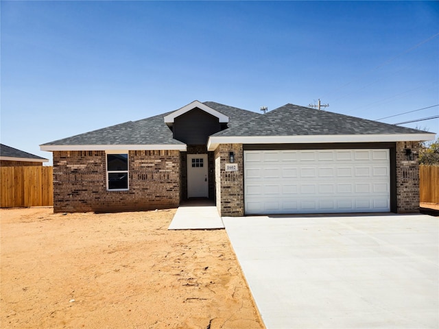 ranch-style home with brick siding, concrete driveway, a garage, and fence