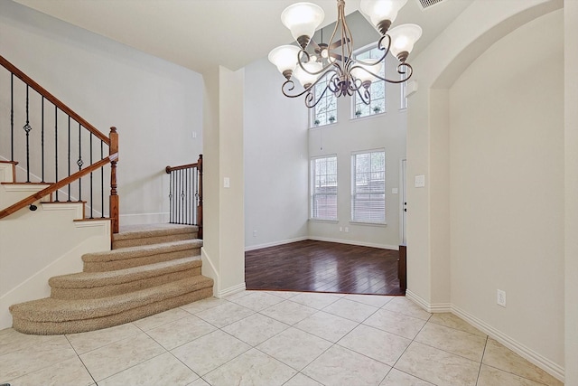 tiled foyer entrance with an inviting chandelier