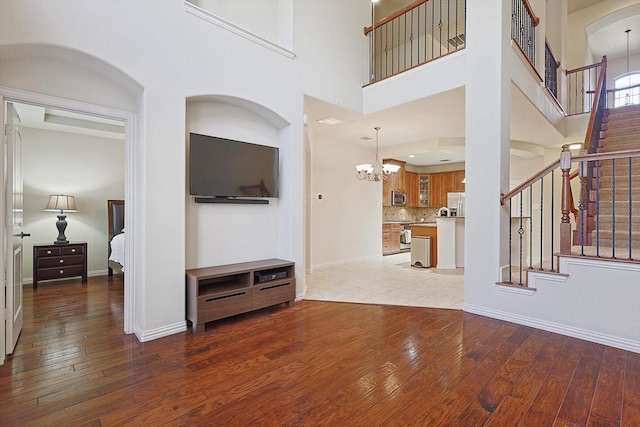 living room featuring a high ceiling, light hardwood / wood-style flooring, and a notable chandelier