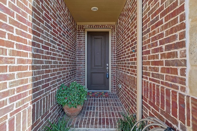 view of exterior entry with brick siding