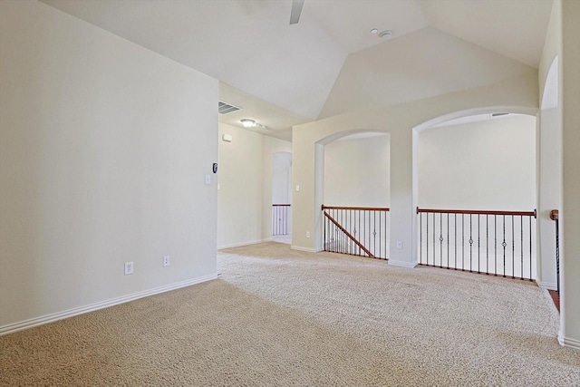 carpeted spare room with vaulted ceiling, visible vents, and baseboards