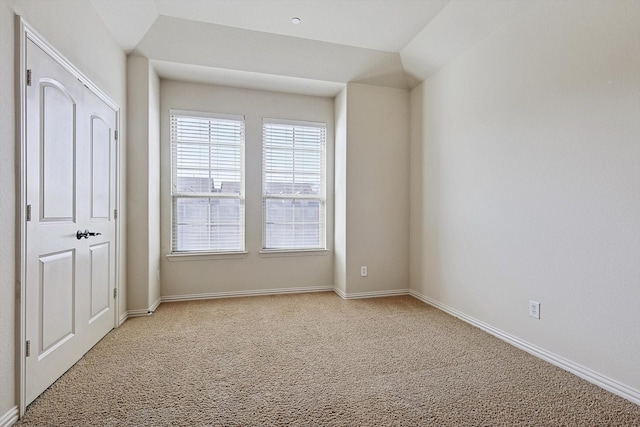 spare room featuring carpet and baseboards