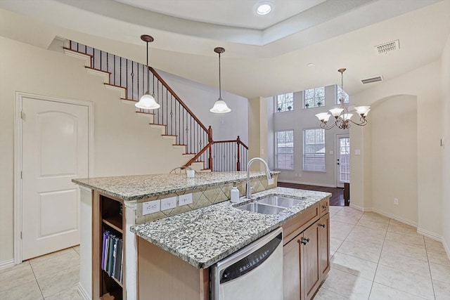 kitchen featuring light tile patterned flooring, a sink, visible vents, dishwasher, and an island with sink