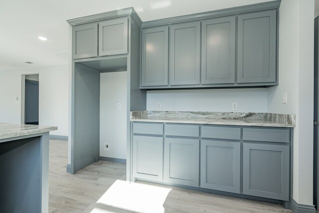 kitchen featuring light stone counters and light hardwood / wood-style flooring