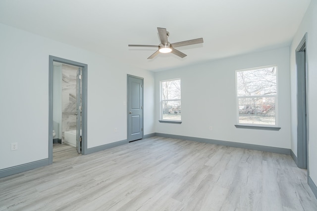 unfurnished bedroom featuring light wood-type flooring, ensuite bathroom, and ceiling fan