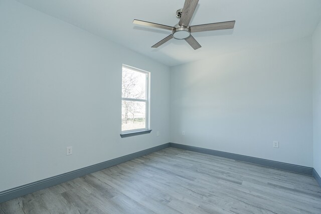 empty room with ceiling fan and light hardwood / wood-style flooring