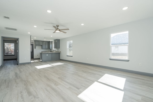 unfurnished living room featuring ceiling fan and light hardwood / wood-style floors