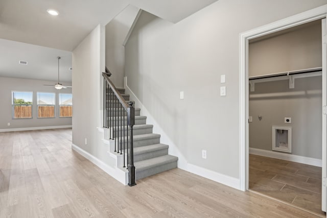 stairway with hardwood / wood-style flooring and ceiling fan