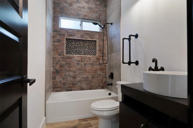 full bathroom featuring toilet, vanity, hardwood / wood-style flooring, and tiled shower / bath combo