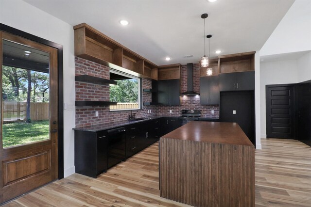 kitchen with a center island, wall chimney exhaust hood, black appliances, and light hardwood / wood-style flooring