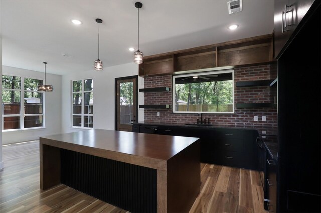 kitchen featuring pendant lighting, a center island, hardwood / wood-style floors, and sink