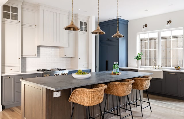 kitchen featuring white cabinets, gray cabinets, a kitchen island, and light hardwood / wood-style floors