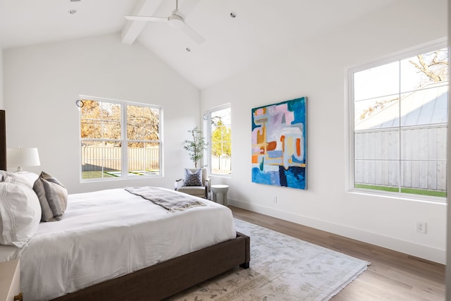 bedroom with vaulted ceiling with beams, light hardwood / wood-style floors, and ceiling fan