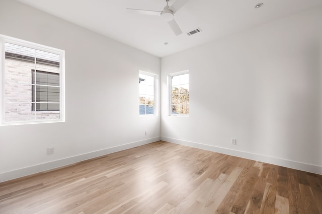 empty room with ceiling fan and light hardwood / wood-style flooring