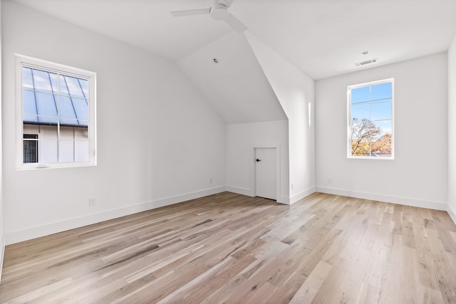 additional living space with light hardwood / wood-style floors, vaulted ceiling, and ceiling fan