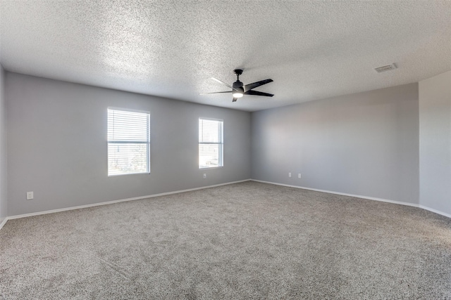 empty room with ceiling fan, carpet floors, and a textured ceiling