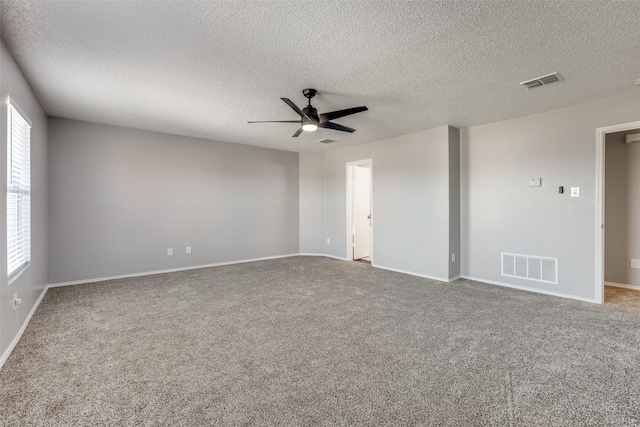 carpeted spare room featuring a textured ceiling and ceiling fan