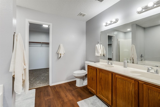 bathroom with vanity, hardwood / wood-style floors, a textured ceiling, and toilet