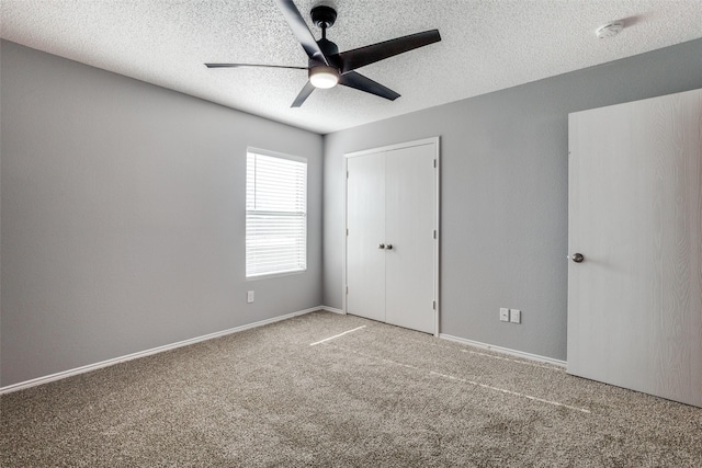 unfurnished bedroom with ceiling fan, a closet, carpet, and a textured ceiling