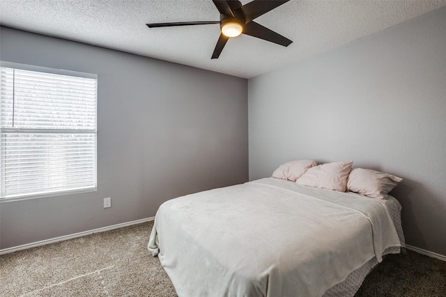 carpeted bedroom with ceiling fan and a textured ceiling