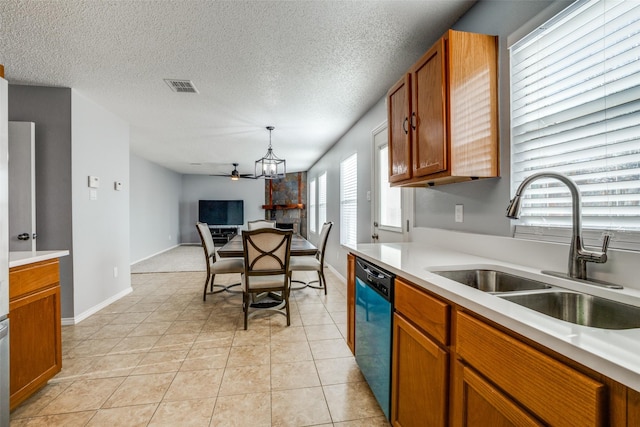 kitchen with pendant lighting, dishwasher, sink, a textured ceiling, and light tile patterned flooring