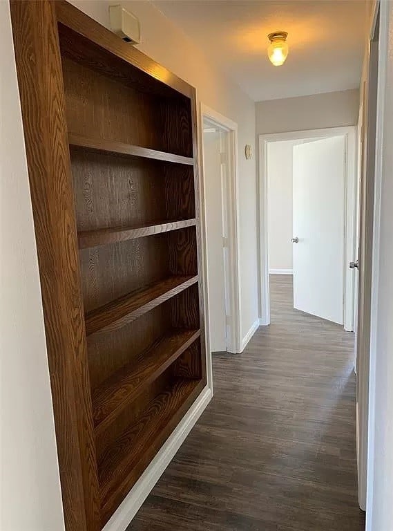 corridor with dark hardwood / wood-style flooring