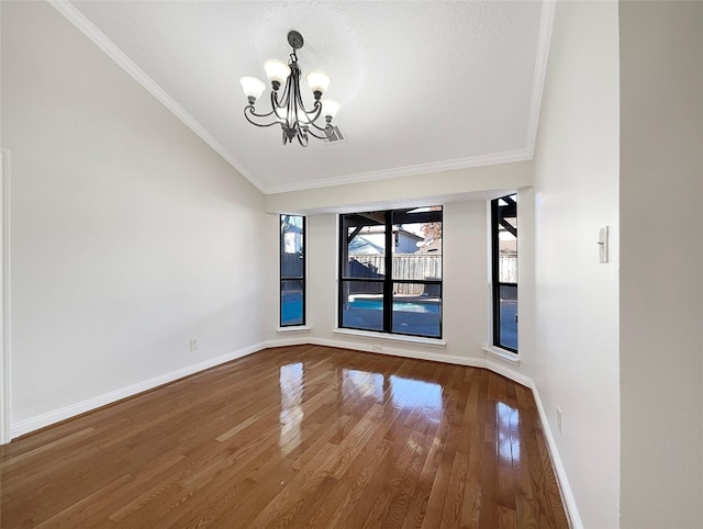 817 Foxridge Dr, Arlington, TX 76017 - empty room with a chandelier, wood finished floors, vaulted ceiling, and crown molding