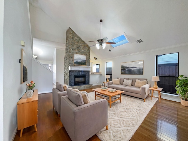 living room with a fireplace, a healthy amount of sunlight, dark hardwood / wood-style flooring, and a skylight