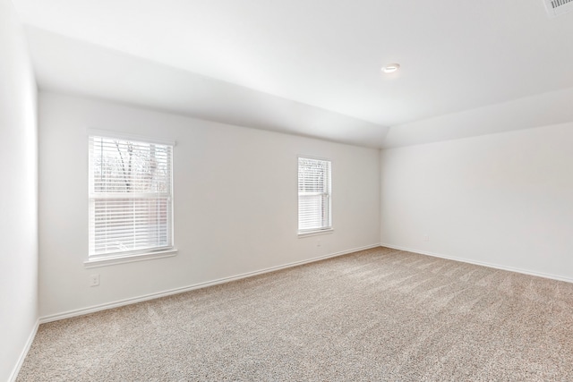 carpeted spare room featuring lofted ceiling