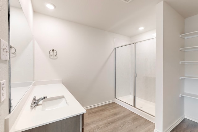 bathroom featuring a shower with door, vanity, and hardwood / wood-style flooring