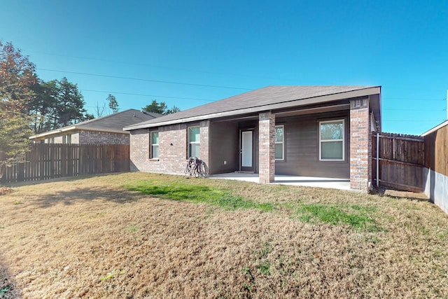 rear view of property featuring a patio and a lawn