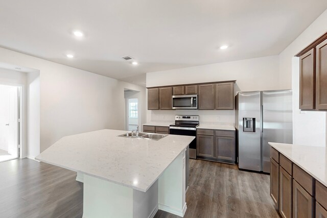 kitchen featuring a kitchen island with sink, sink, hardwood / wood-style flooring, and appliances with stainless steel finishes