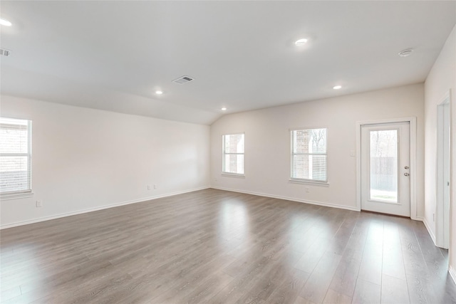 spare room featuring dark wood-type flooring and lofted ceiling