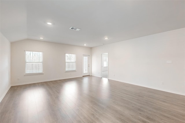 unfurnished room featuring hardwood / wood-style floors and lofted ceiling